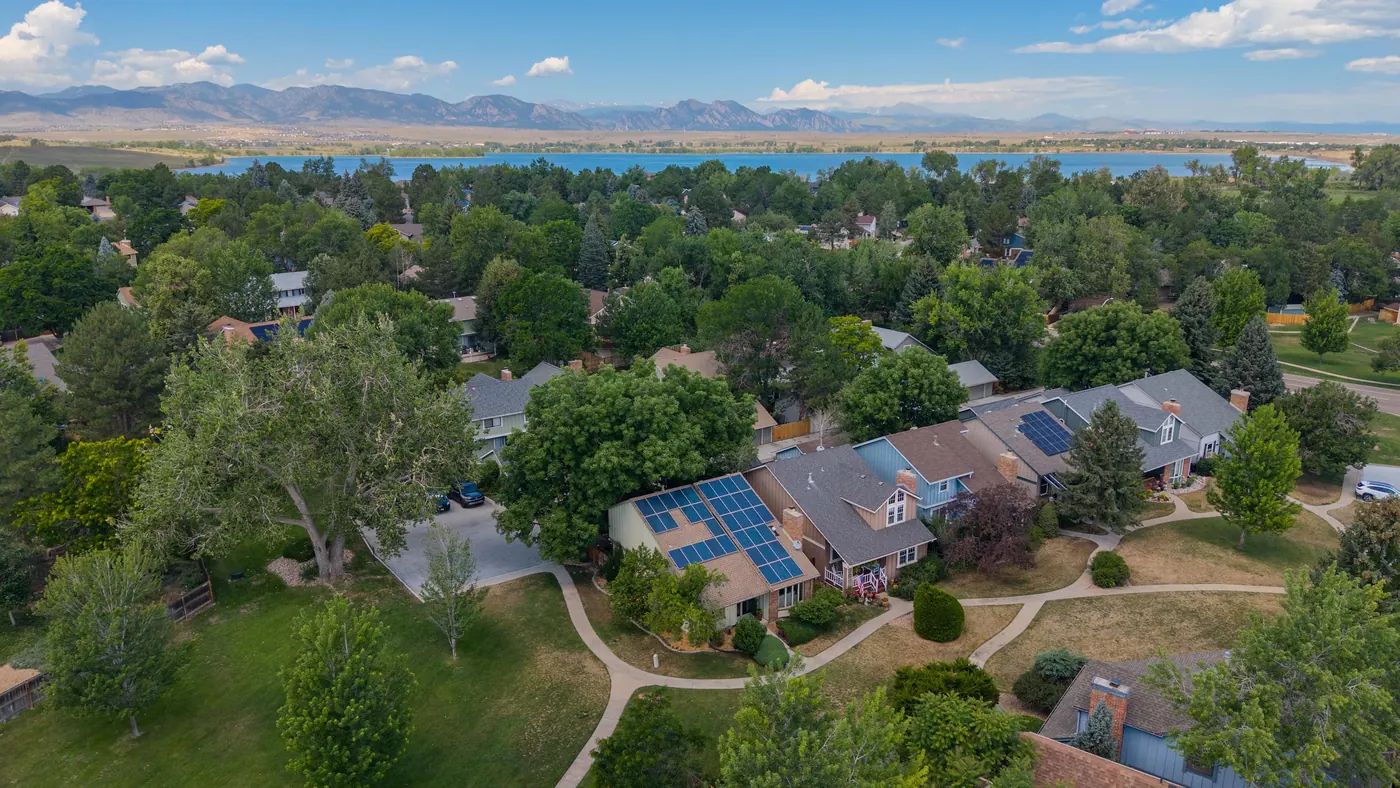 Neighborhood greenbelt winding past the home with the foothills on the horizon