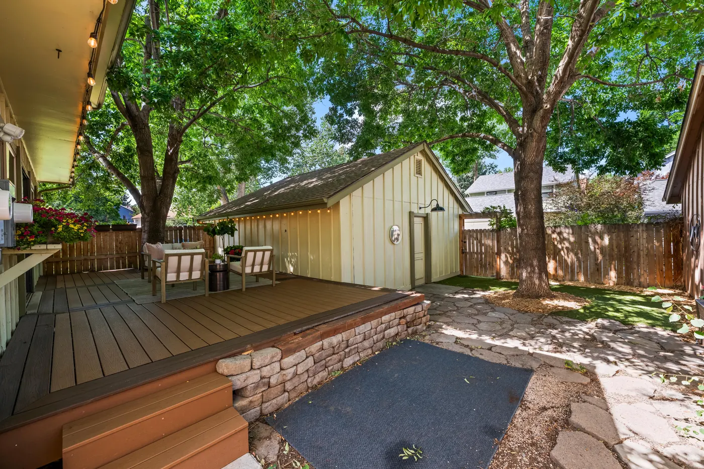 Flagstone path from the deck to the garage under a mature shade tree